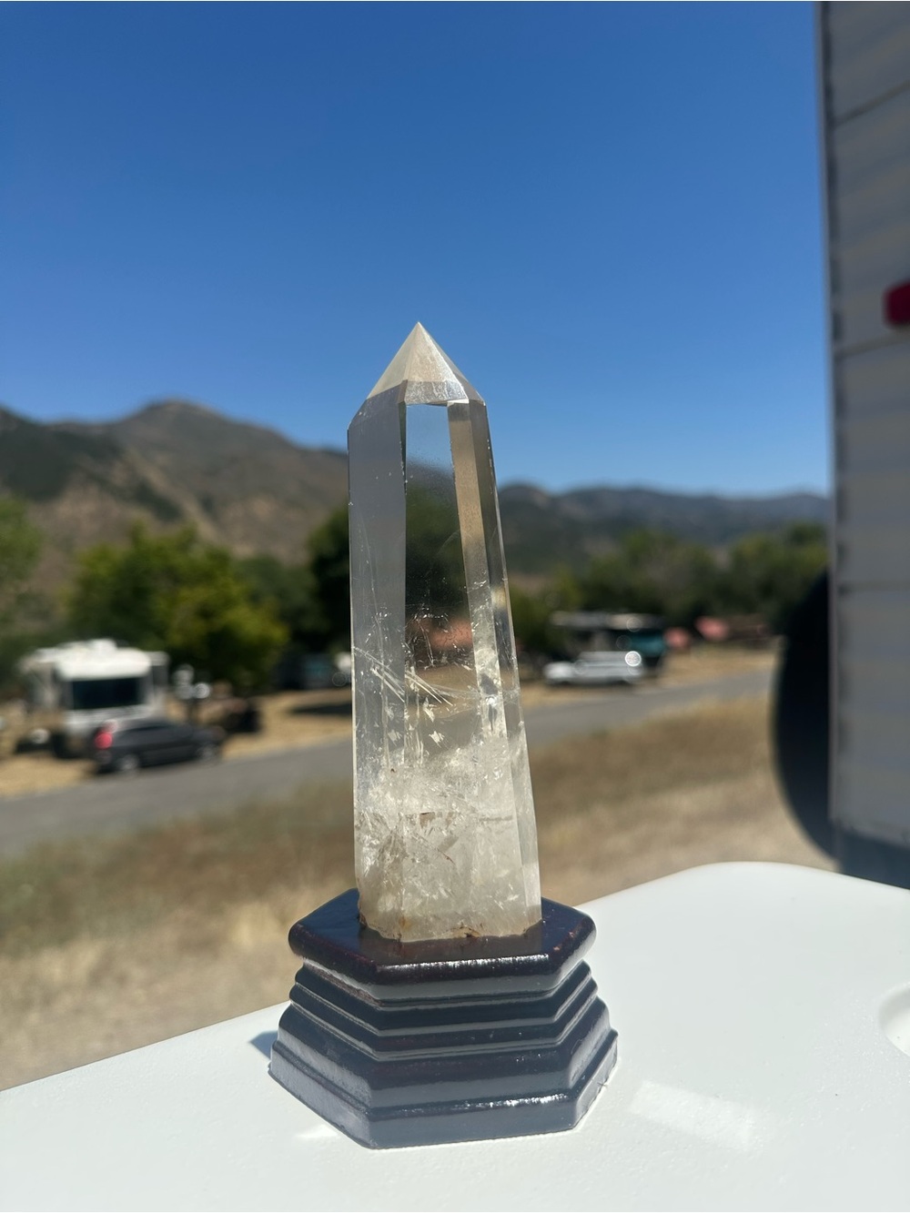 Clear Quartz Point Crystal on Black wooden stand